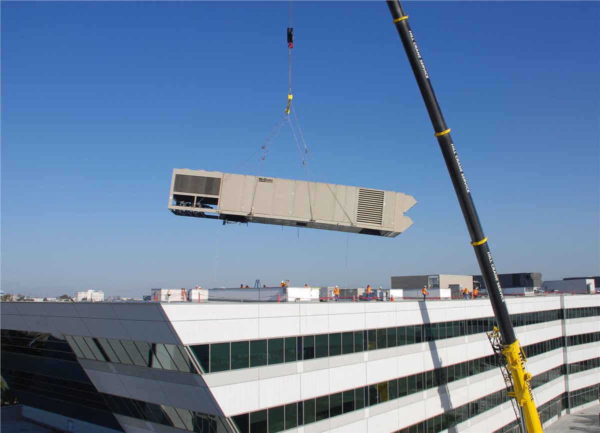 Crane lifting an air-handling unit at a building